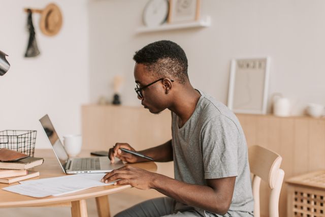 a person using a laptop and taking notes